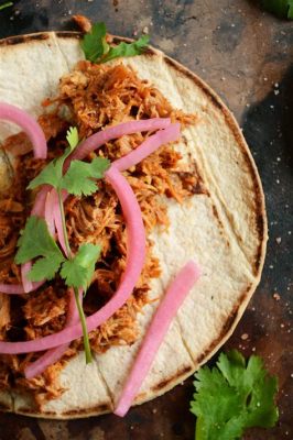  Cochinita Pibil:  An Unforgettable Symphony of Slow-Cooked Pork and Earthy Spices Explodes on Your Palate!